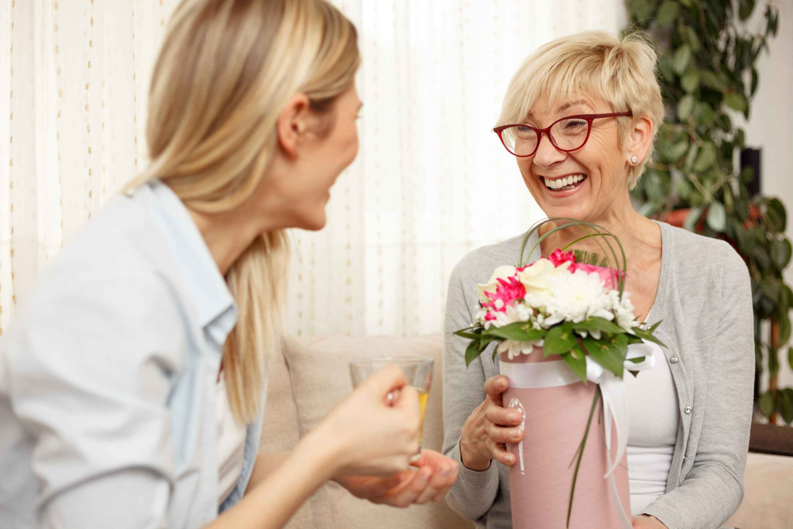 Happy Mother and daughter laughing on a sofa. Mother's day. Happy family moments at home